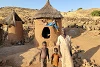 Zanab avec ses deux petits-enfants devant sa minuscule maison. csi